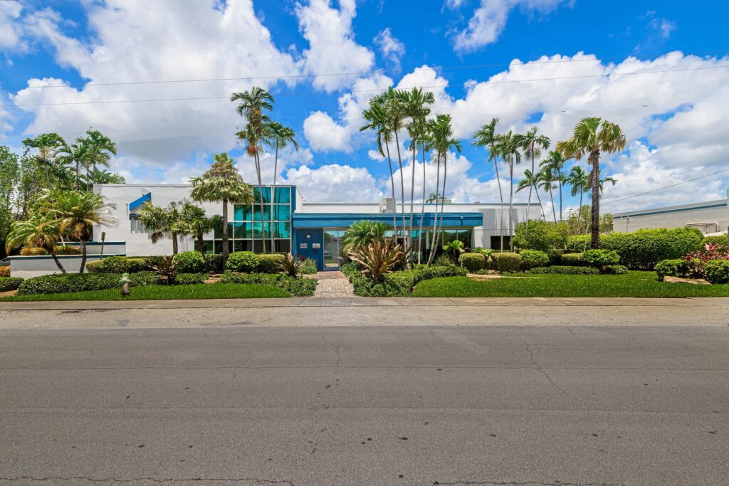 Exterior view of i95 Flex Office Compound commercial office property in Hollywood Florida with palm trees and professional office building entrance